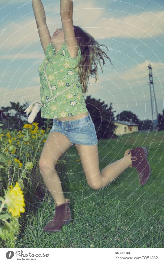 angeblitzt einen ball fangen Kind Mädchen Außenaufnahme Sommer Abenddämmerung Landschaft Sonnenblumenfeld Strommast Haus hüpfen springen Arme Himmel