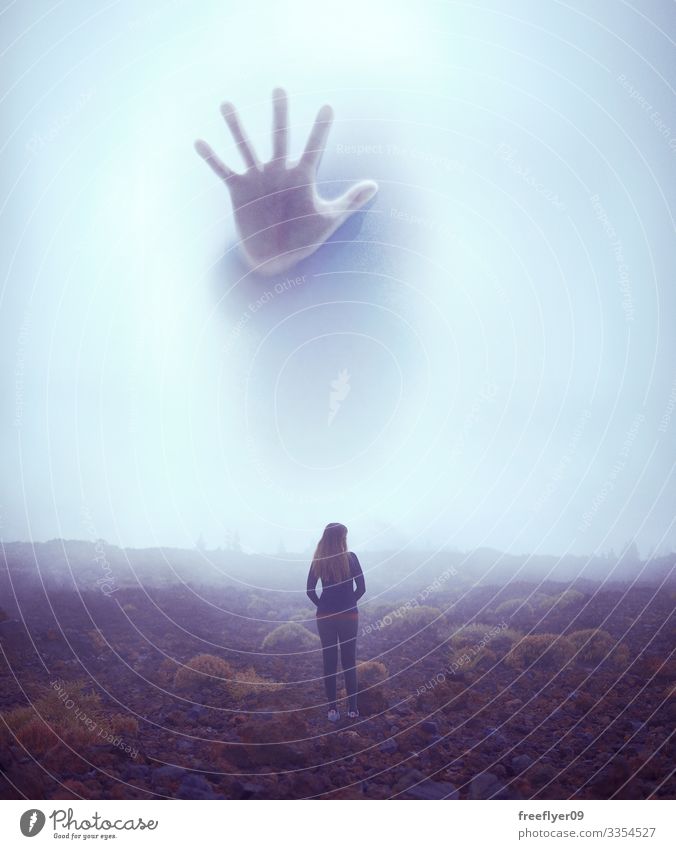 Junge Frau vor einer riesigen Kreatur, die sich im Nebel versteckt jung Angst Riese geheimnisvoll Mysterium im Freien vertikal winzig Monster bedrohlich