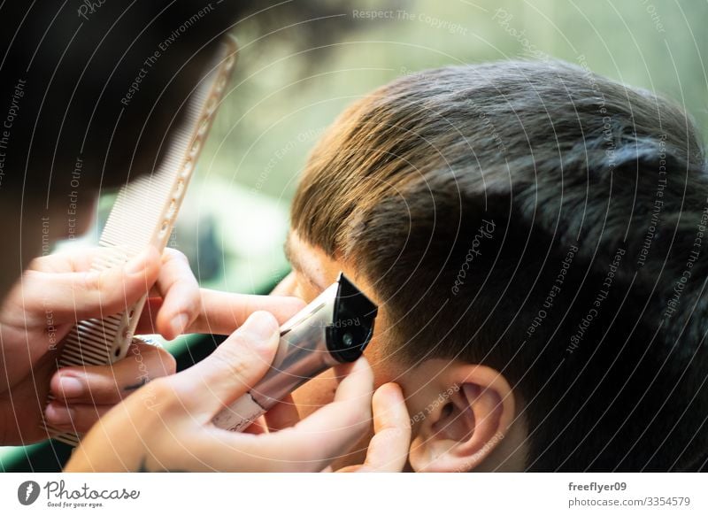 Nahaufnahme eines arbeitenden Barbiers Mann Friseur Klient professionell Stil Pflege Design Erwachsener Frisur jung Behaarung Kosmetikerin Hand Haarschnitt Kamm