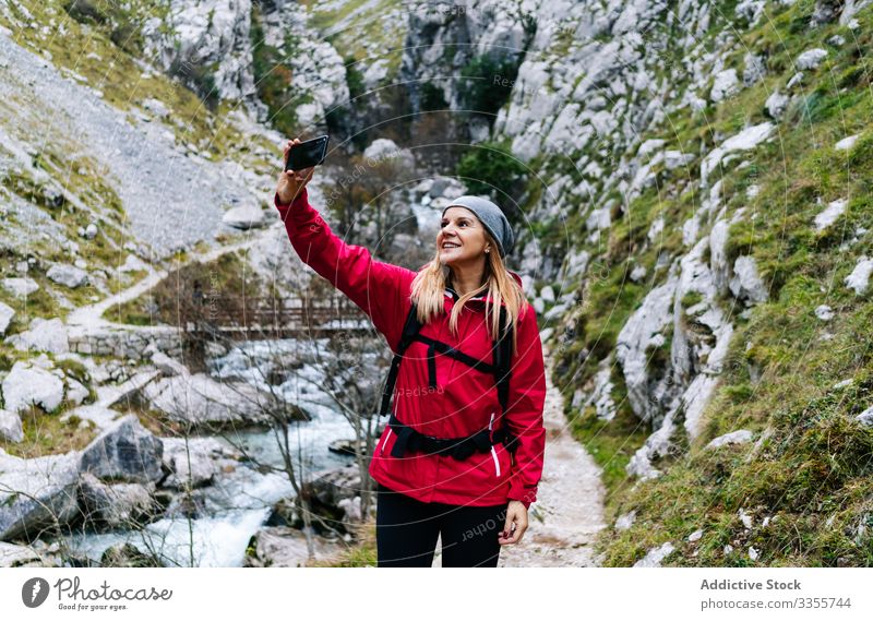 Frau mit Rucksack nimmt sich auf dem Smartphone auf dem Hintergrund der Berge mit Tourist Selfie Berge u. Gebirge benutzend reisen Natur Gerät Apparatur