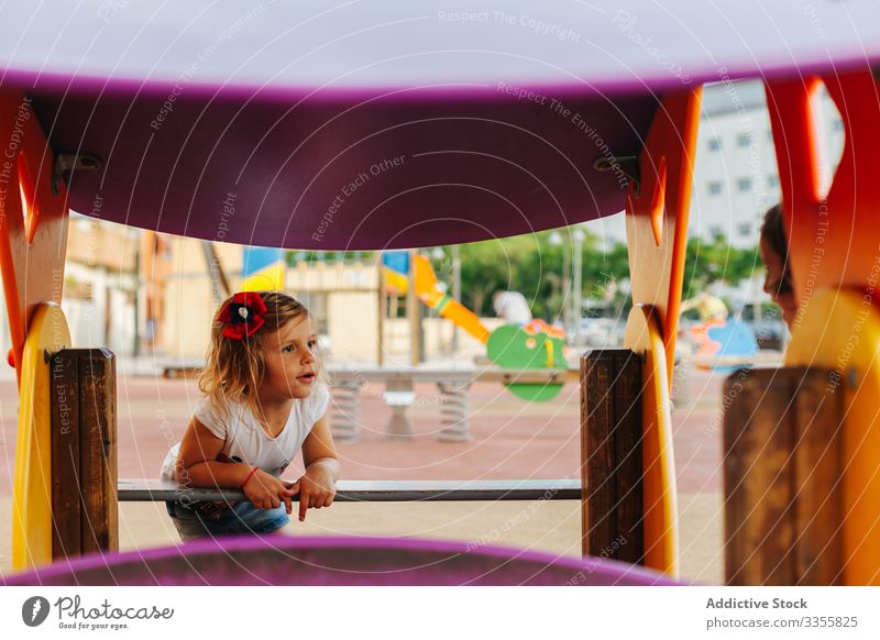 Lustiges Mädchen spielt auf dem Spielplatz spielen Reling hinausschauen Spaß ruhen Kind Kindheit sich[Akk] entspannen Lifestyle neugierig Vorstellungskraft