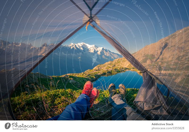 Entspannte Touristen liegen im Zelt in verschneiten Bergen im Sonnenlicht Berge u. Gebirge Felsen See Reflexion & Spiegelung Kristalle übersichtlich Natur