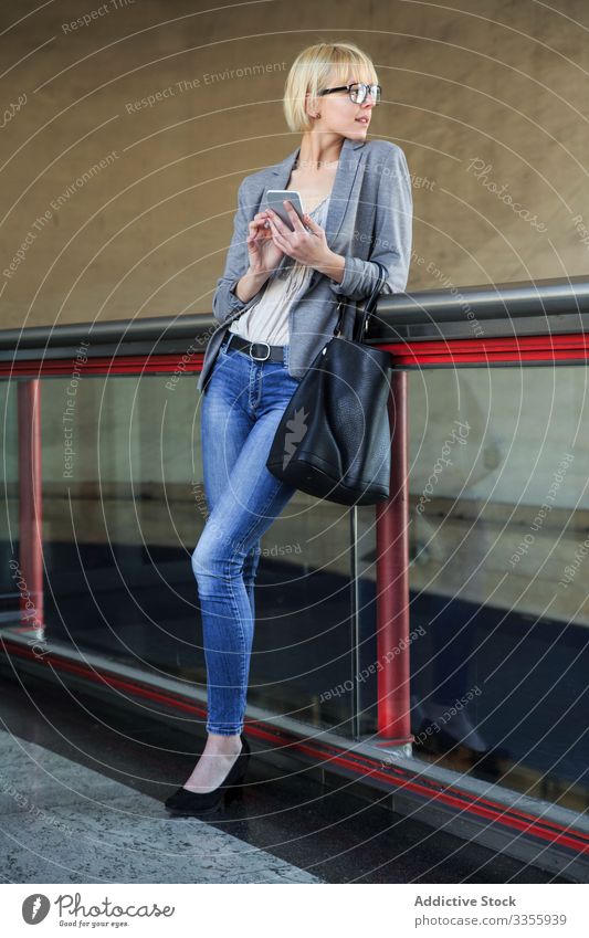 Geschäftsfrau mit Smartphone stylisch jung Telefon Mobile Anschluss heiter Geländer Lehnen Frau professionell Person schön benutzend Browsen attraktiv