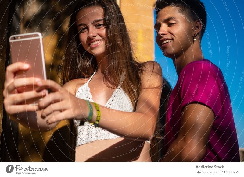 Charmante junge Dame, die mit einem zufriedenen ethnischen Mann telefoniert Freund Selfie Telefon benutzend sich[Akk] entspannen Lächeln Glück gutaussehend Foto