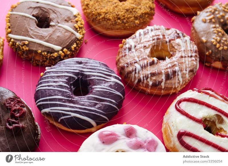 Vielfalt von Donuts auf rosa Hintergrund Doughnut Varieté Sortiment süß Zuckerguß verglast Lebensmittel Krapfen Bäckerei Gebäck bestäuben gebraten farbenfroh