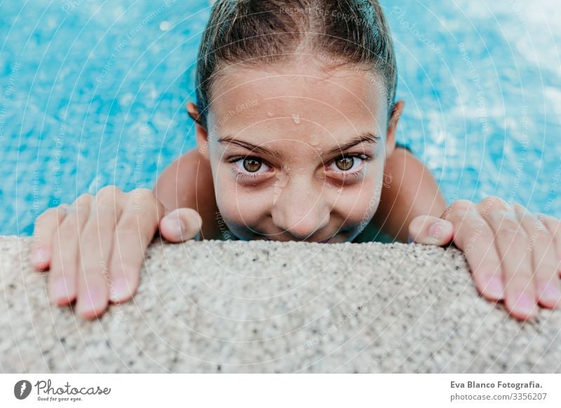 Ein wunderschöner Teenager schwebt in einem Pool und schaut in die Kamera. Spaß und sommerlicher Lebensstil Aktion Schwimmbad Beautyfotografie Außenaufnahme