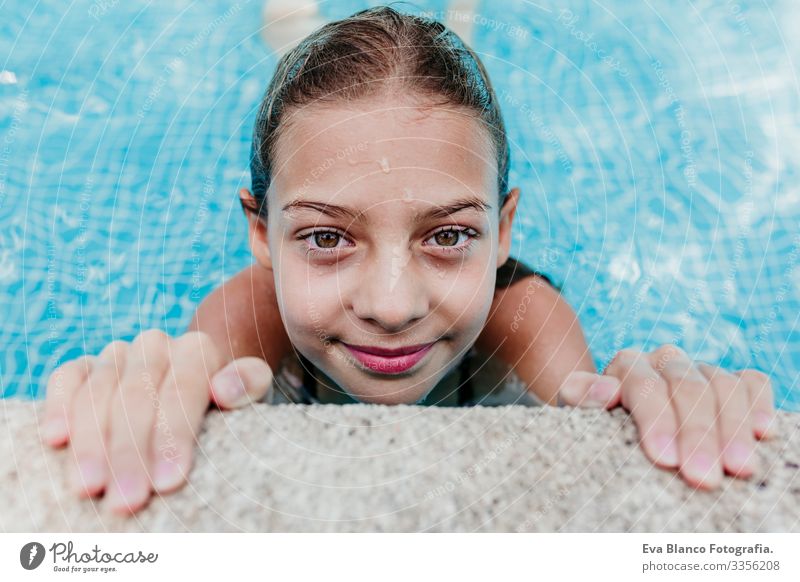 Ein wunderschöner Teenager schwebt in einem Pool und schaut in die Kamera. Spaß und sommerlicher Lebensstil Aktion Schwimmbad Beautyfotografie Außenaufnahme