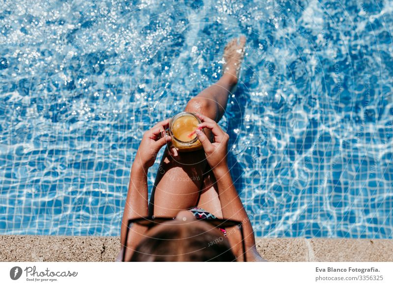 schönes Mädchen am Pool, Sommerzeit Sonnenlicht Tag orange trinken Außenaufnahme jung Badebekleidung Wasser Genuss Schwimmsport Kinder Kaukasier spielerisch