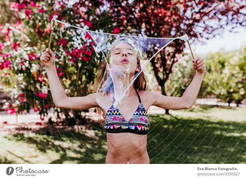 süßes Mädchen, das draußen mit Seifenblasen spielt, Sommerzeit Lifestyle Schwimmbad Ferien & Urlaub & Reisen Sonne Gesundheit Kaukasier Lächeln blau Genuss