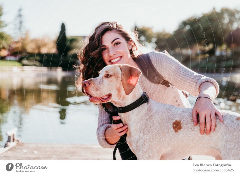 junge Frau und ihr Hund im Freien in einem Park mit einem See. sonniger Tag, Herbstsaison Jugendliche Außenaufnahme Liebe Haustier Besitzer Sonnenstrahlen schön