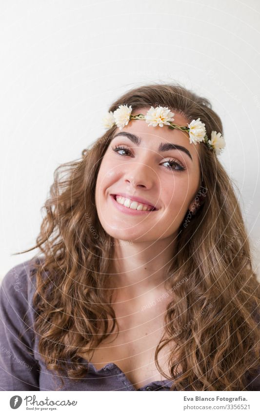 Porträt einer jungen schönen Frau, die einen Blumenkranz trägt. Sie lächelt, drinnen. Lebensstil. Vertikale Ansicht. Kopf elegant erstaunlich aromatisch