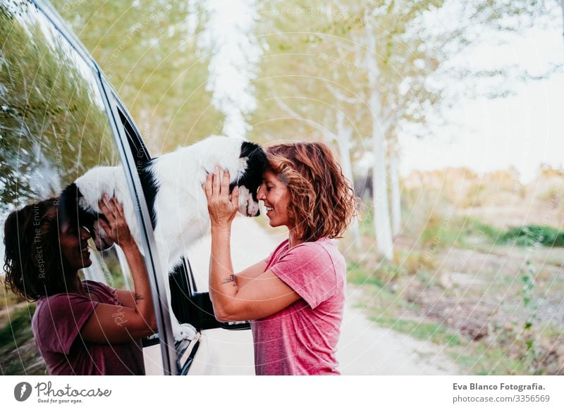 Frau, die ihren Border-Collie-Hund in einem Lieferwagen umarmt. Reisekonzept Border Collie Kleintransporter Van Leben Ferien & Urlaub & Reisen reisend Besitzer
