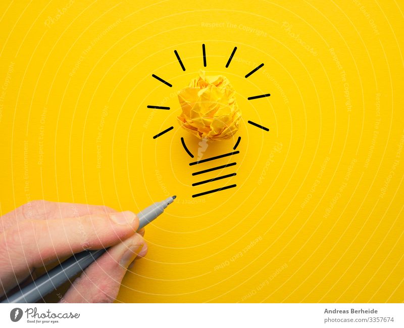 Gelbe zerknitterte Papierkugel als Glühbirne Knolle Hand Licht Idee Lampe Energie Konzept Zeichnung Geschäftsmann Kraft Elektrizität Business hell elektrisch
