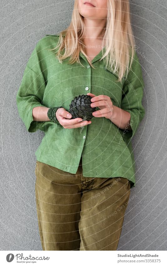 Frau in grüner Kleidung mit Artischocke schön Sommer Mensch Junge Frau Jugendliche Erwachsene Kunst Mode Bekleidung Hemd Hose Jeanshose blond langhaarig Metall