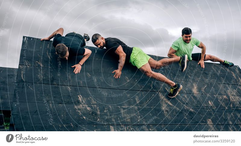 Teilnehmer des Hindernislaufs klettern an der umgekehrten Wand Lifestyle Sport Klettern Bergsteigen Mensch Mann Erwachsene Menschengruppe authentisch stark