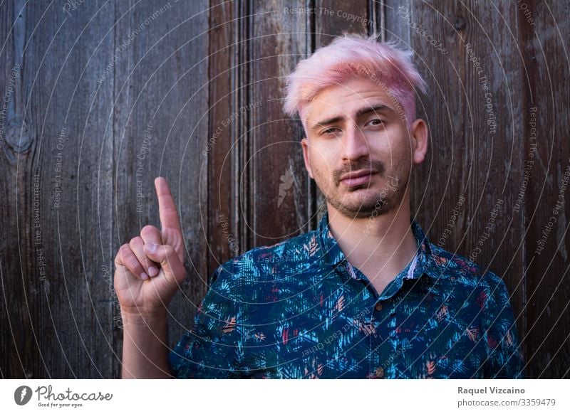 Mann zeigt mit dem Finger nach oben. Sommer Erwachsene 1 Mensch 18-30 Jahre Jugendliche Freundlichkeit modern blau braun rosa Punkt weisen Sie darauf hin