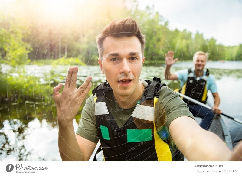 Zwei Männer in Rettungswesten beim Kanufahren auf einem Waldsee. Aktion Abenteuer Ausflugsziel entdecken Finnland Glück Ferien & Urlaub & Reisen Lifestyle Mann
