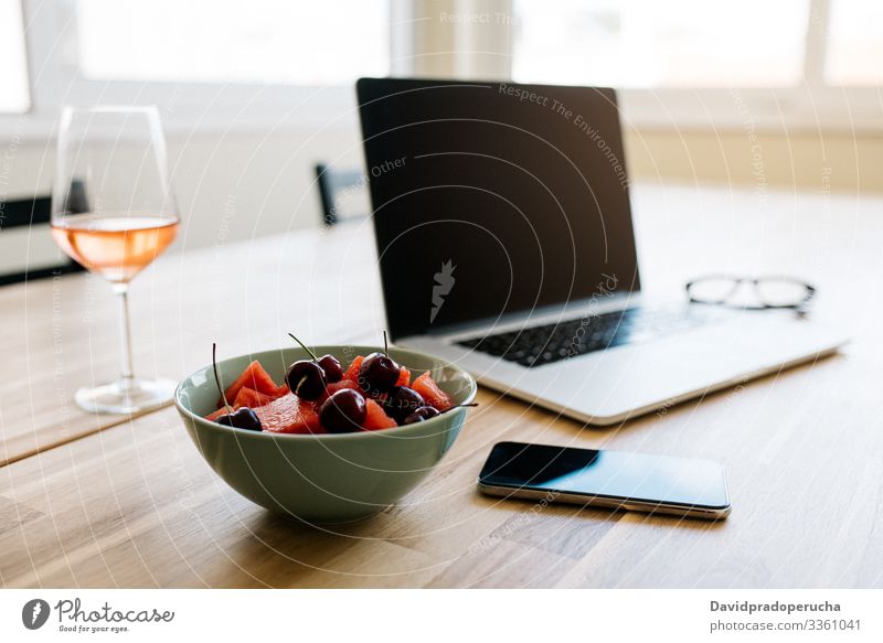 Komfortabler Arbeitsbereich mit Geräten und frischen Beeren auf dem Tisch Laptop freiberuflich sich[Akk] entspannen Wein Frucht Schalen & Schüsseln Pause Kälte