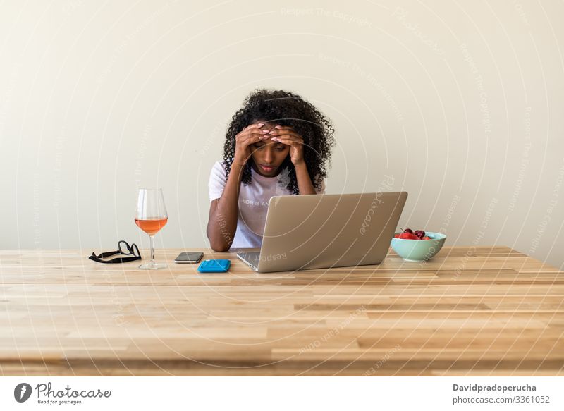 Afroamerikanische Freiberuflerin benutzt Laptop zu Hause Frau Tisch Wein benutzend Kälte Browsen Wochenende freiberuflich ethnisch Afroamerikaner schwarz allein