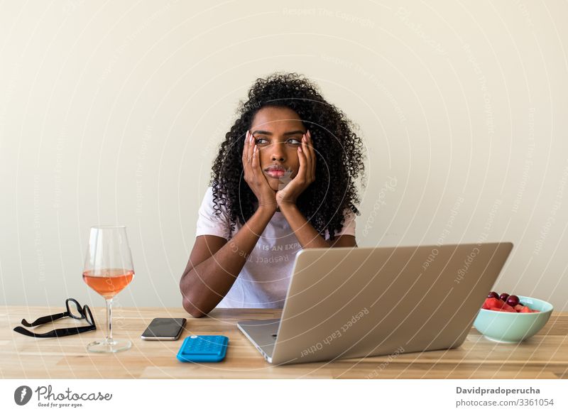 Afroamerikanische Freiberuflerin benutzt Laptop zu Hause Frau Tisch Wein benutzend Kälte Browsen Wochenende freiberuflich ethnisch Afroamerikaner schwarz allein