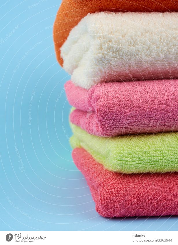 gefaltete Handtücher aus farbigem Baumwollfrottee Lifestyle Design Körper Erholung Spa Massage Bad Stoff frisch neu Sauberkeit weich blau grün rosa weiß Farbe