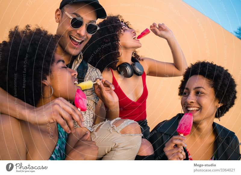 Eine multiethnische Gruppe von Freunden genießt die Sommerzeit beim Eisessen. Freundschaft jung Menschen Dessert Essen Vielfalt vielfältig genießen Vergnügen