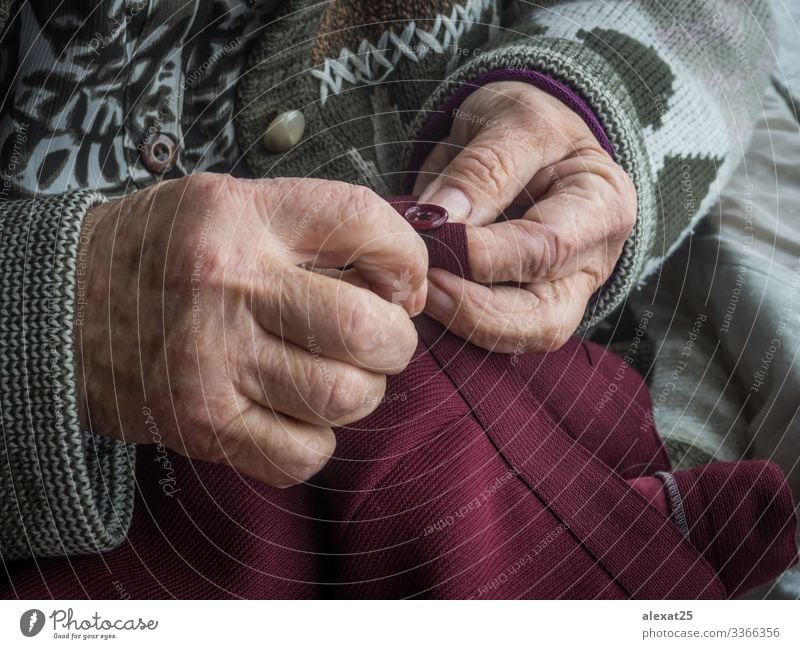 Ältere Frauenhände beim Nähen eines Knopfes Freizeit & Hobby Handwerk Erwachsene Großmutter alt Lebensalter Hintergrund Knöpfe schließen Stickereien Oma