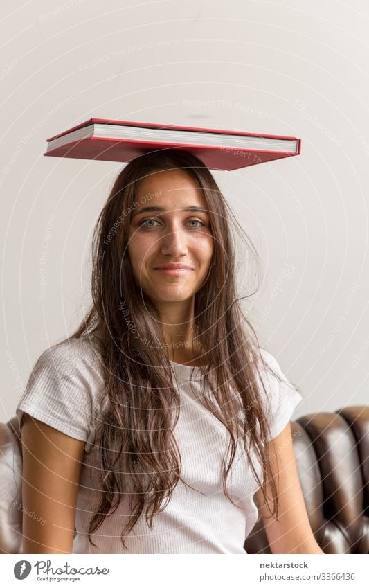 Porträt einer jungen Frau mit Buch auf dem Kopf Mädchen junger Erwachsener Jugendkultur Tag urban weibliche Schönheit schöne Frau natürliche Schönheit