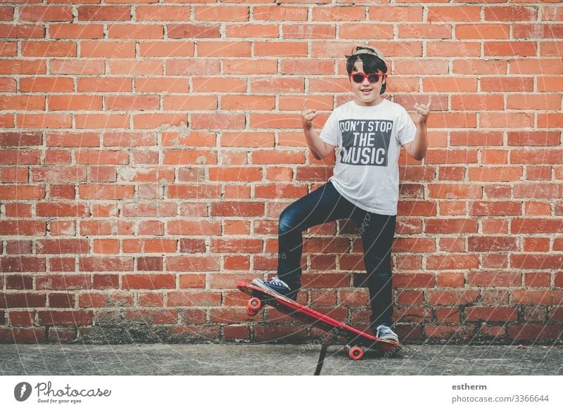Kind mit Skateboard und Sonnenbrille macht Rocksymbol mit erhobenen Händen Lifestyle Freude Freizeit & Hobby Freiheit Sommer Musik Sport Fitness Sport-Training