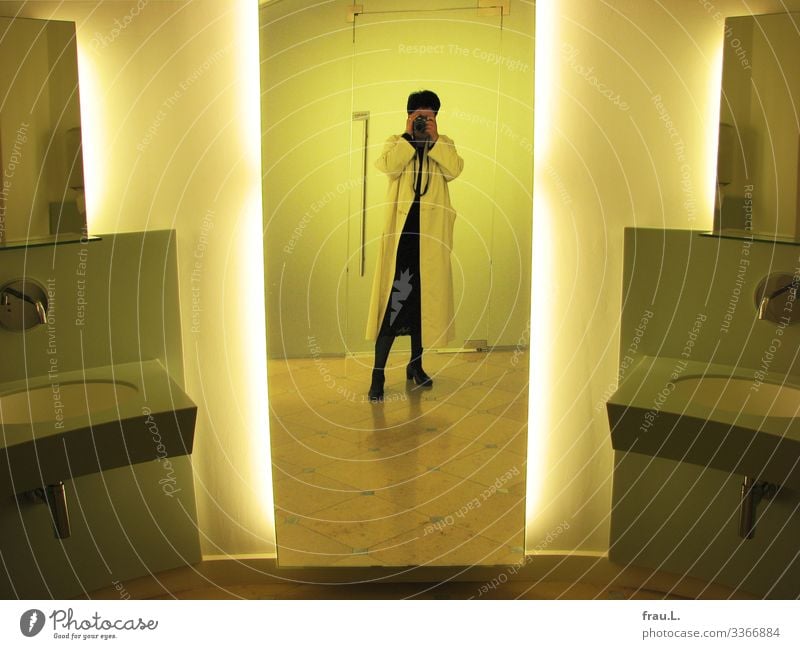 Waschraum Mensch feminin Frau Erwachsene 1 45-60 Jahre Mantel Stiefel schwarzhaarig kurzhaarig stehen außergewöhnlich gelb Spiegel Waschhaus Toilette Museum