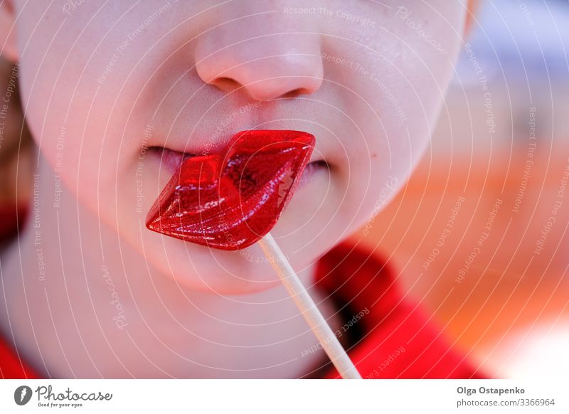 Mädchen küsst einen lippenförmigen Lolli Herz schön Liebe Küssen Jugendliche rot Süßwaren Lollipop Frau Beautyfotografie süß Bonbon Glück Tag lecker