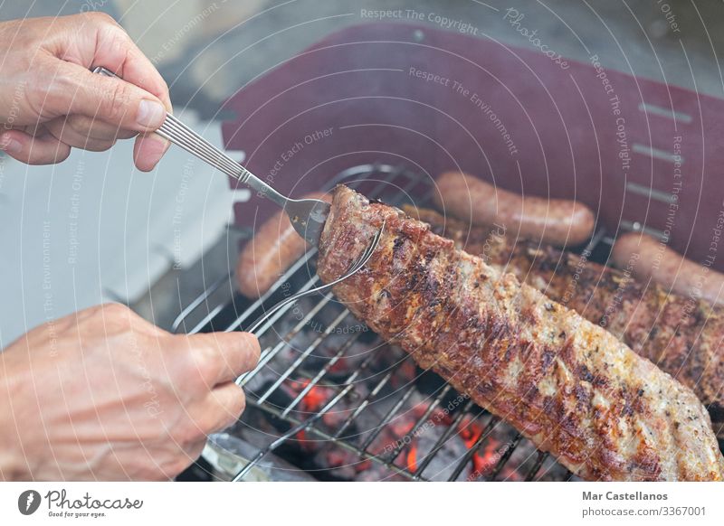 Hände, die Schweinekoteletts auf dem Grill wenden. Begriff der Nahrung. Fleisch Gabel Restaurant Feste & Feiern Arbeit & Erwerbstätigkeit Mensch