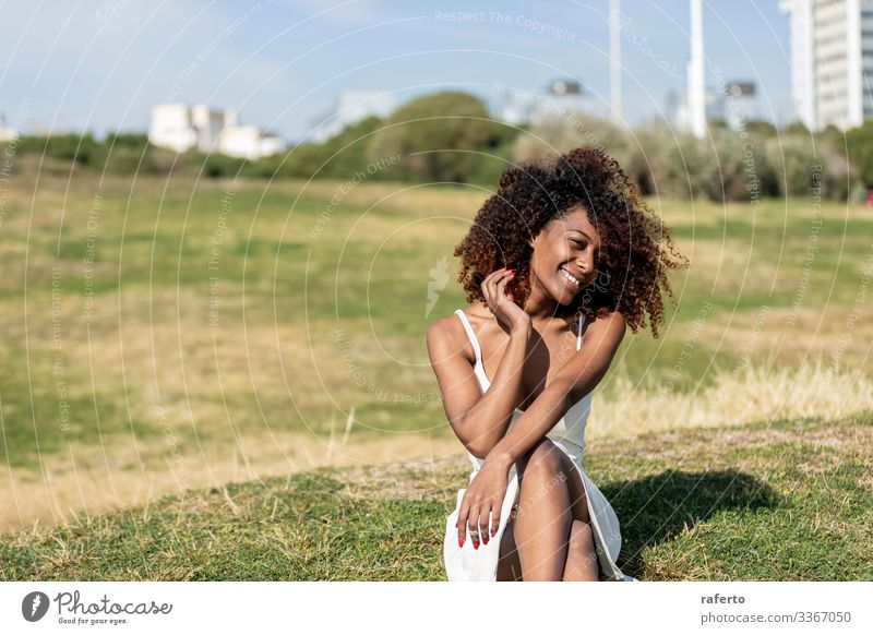 afroamerikanische Frau mit weißem Kleid, die im Gras sitzt Lifestyle Stil schön Gesicht Mensch feminin Junge Frau Jugendliche Erwachsene 1 18-30 Jahre Park Mode