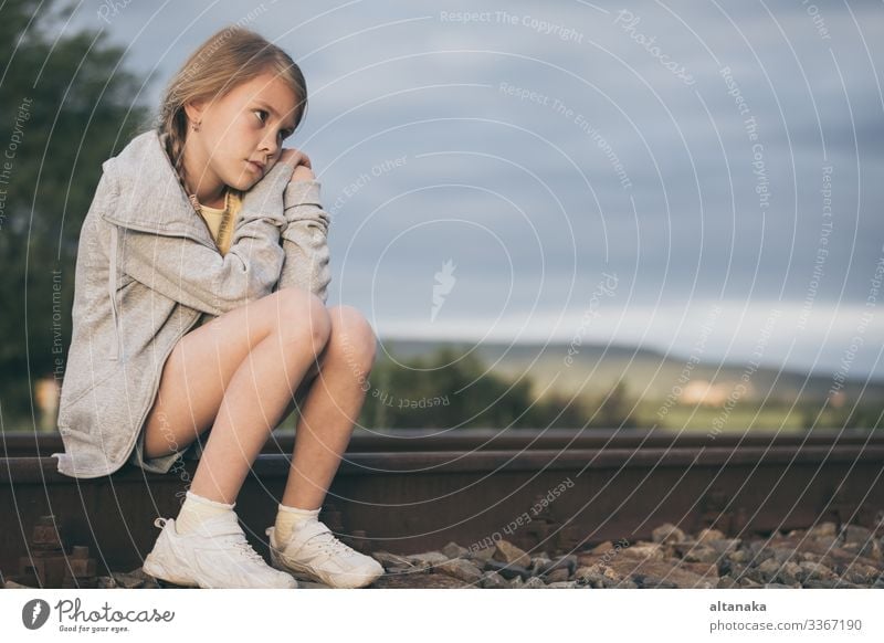 Porträt eines jungen, traurigen Mädchens, das tagsüber im Freien auf der Bahn sitzt. Konzept der Trauer. Gesicht Kind Mensch Frau Erwachsene