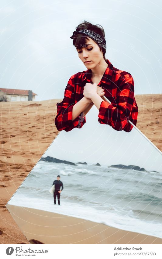 Traurige Frau mit großem Spiegel am Strand stehend Konzept Reflexion & Spiegelung MEER ernst traurig Surfer Paar besinnlich stürmisch lässig jung Meer Sand