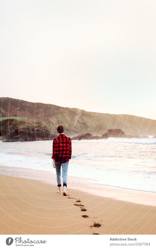 Frau geht am Strand auf nassem Sand Fußspur Spaziergang Konzept MEER Barfuß Meer Wasser Natur reisen Küste Seeküste Umwelt einsam bedeckt wolkig Wellen trist