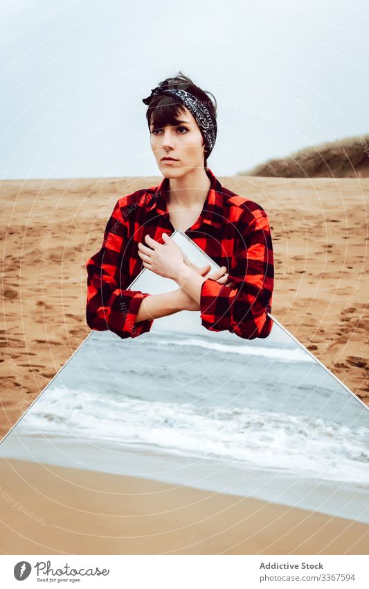 Einsame nachdenkliche Frau mit großem Spiegel am Strand stehend Konzept Reflexion & Spiegelung MEER einsam traurig stürmisch besinnlich lässig jung Meer Sand