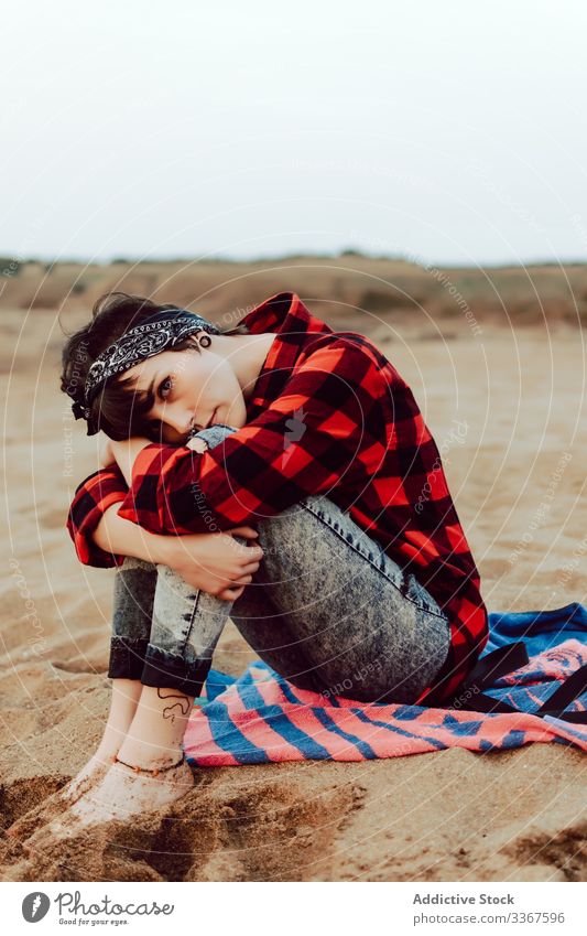Nachdenkliche Hipster-Frau sitzt am Sandstrand Strand besinnlich sitzen ernst jung sich[Akk] entspannen nachdenklich MEER lässig Meer Beobachtung Denken rot