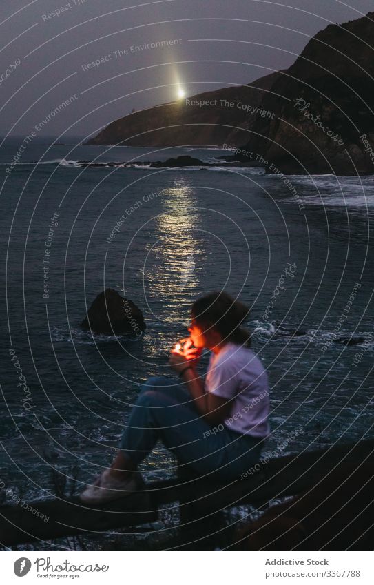 Frau raucht abends am Meer Küste Rauch Zigarette lässig Abenddämmerung Dämmerung MEER Natur besinnlich Nacht nachdenklich sich[Akk] entspannen Wasser Felsen