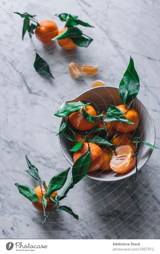 Orangefarbene Mandarinen in Keramik-Ornamentschale auf Marmortisch anspruchsvoll Frucht Gesundheit klassisch Schalen & Schüsseln Zusammensetzung Stillleben
