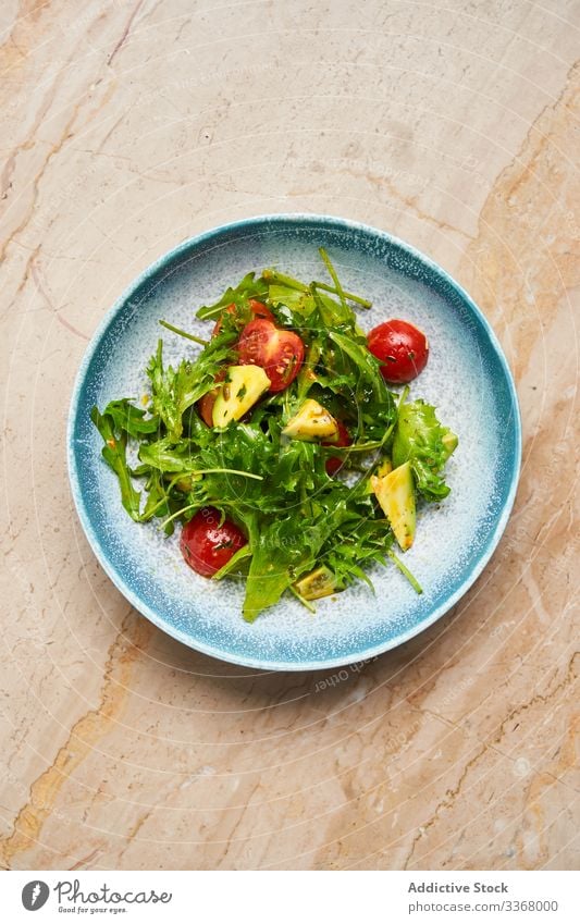 Frischer Vitaminsalat mit Rucola und Tomaten Salatbeilage Avocado Rakete Olivenöl Schalen & Schüsseln Teller Speise Restaurant Gemüse Scheibe Kraut Saucen