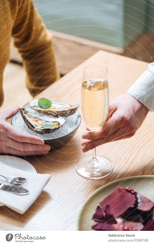 Erntehelfer genießt Austern und Champagner Person essen trinken Restaurant Zitrone Kraut Eis Tisch Muschel Meeresfrüchte Exquisit lecker geschmackvoll