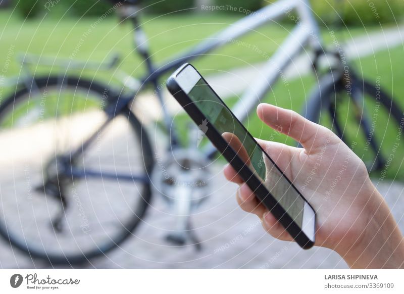Smartphone in der Hand Frau und verschwommenes Fahrrad Lifestyle Ferien & Urlaub & Reisen Sport Telefon PDA Bildschirm Technik & Technologie Internet Mensch