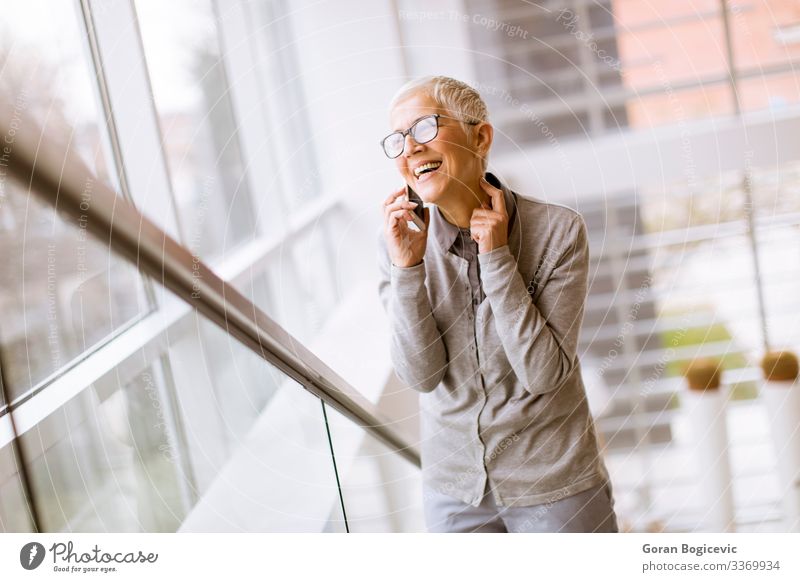 Ältere Geschäftsfrau benutzt Mobiltelefon in der modernen Stadt Lifestyle Erfolg Arbeitsplatz Büro Business Telefon PDA Notebook Technik & Technologie Internet