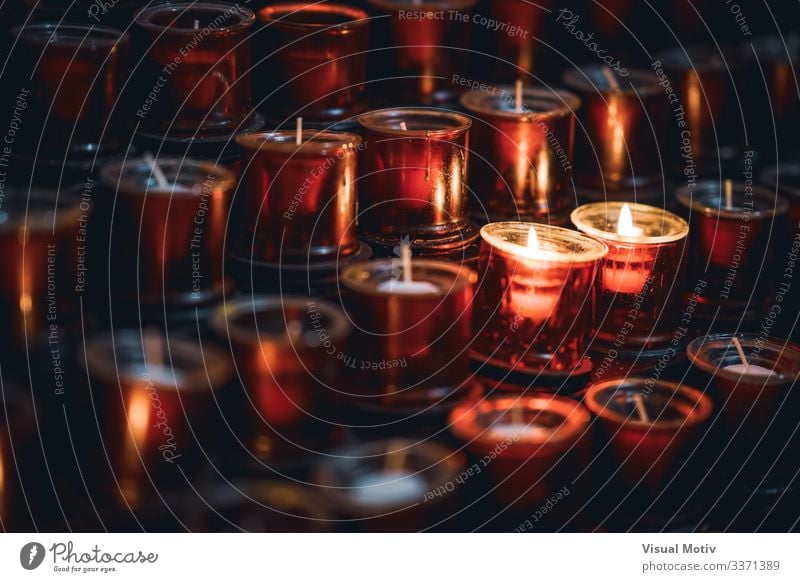 Zwei brennende Kerzen zwischen mehreren Reihen von roten Kerzen in einer Kirche Erholung Meditation Wärme hell Hoffnung Farbe Frieden Glaube Religion & Glaube