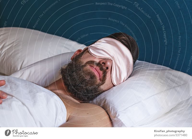 Nahaufnahme eines bärtigen Mannes mit Augenmaske, der im Bett schläft Lifestyle Gesicht Erholung Ferien & Urlaub & Reisen Schlafzimmer Mensch Erwachsene Mode