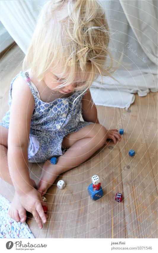 Würfelspiel Freude Gesundheit Spielen Kinderspiel Wohnzimmer lernen feminin Kleinkind Mädchen Kindheit Körper blond Vorhang Bewegung sitzen Glück Neugier blau