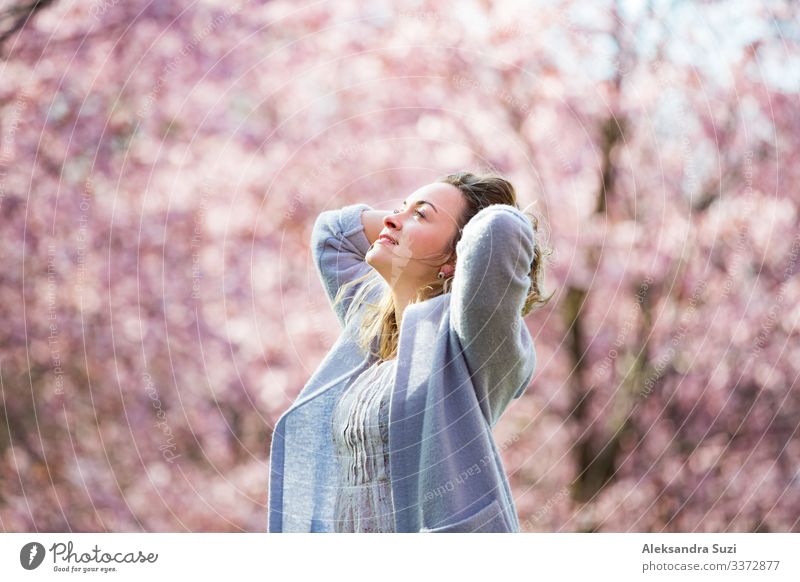 Junge Frau genießt die Natur im Frühling. Tanzen, laufen und wirbeln in schönen Park mit Kirschbäumen in der Blüte. Glück Konzept Beautyfotografie Körperpflege