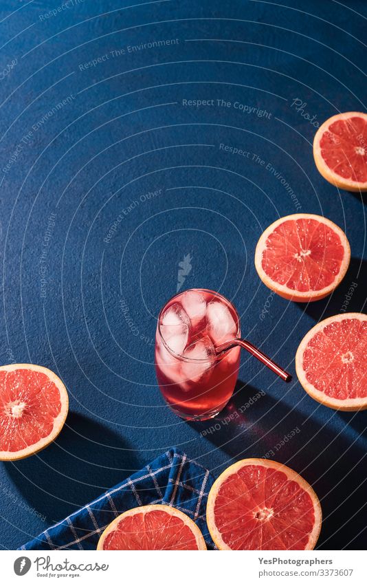 Bio-Grapefruitscheiben und Kaltgetränk. Limonade Frucht Getränk Erfrischungsgetränk Saft Glas saftig Farbe Blauer Hintergrund blauer Tisch Zitrusfrüchte