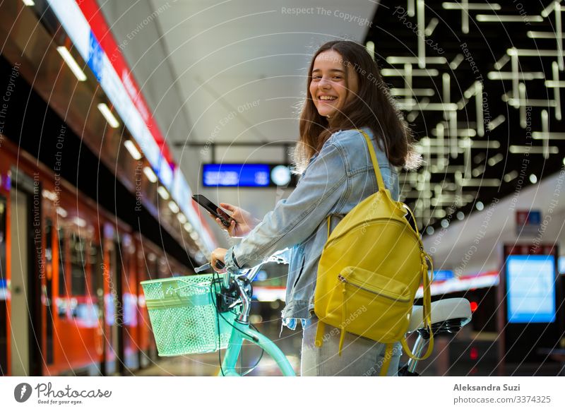 Jugendliche mit Rucksack und Fahrrad in der U-Bahn-Station Aktion Fahrradfahren lässig Freizeitbekleidung Freundlichkeit heiter Großstadt Ausflugsziel